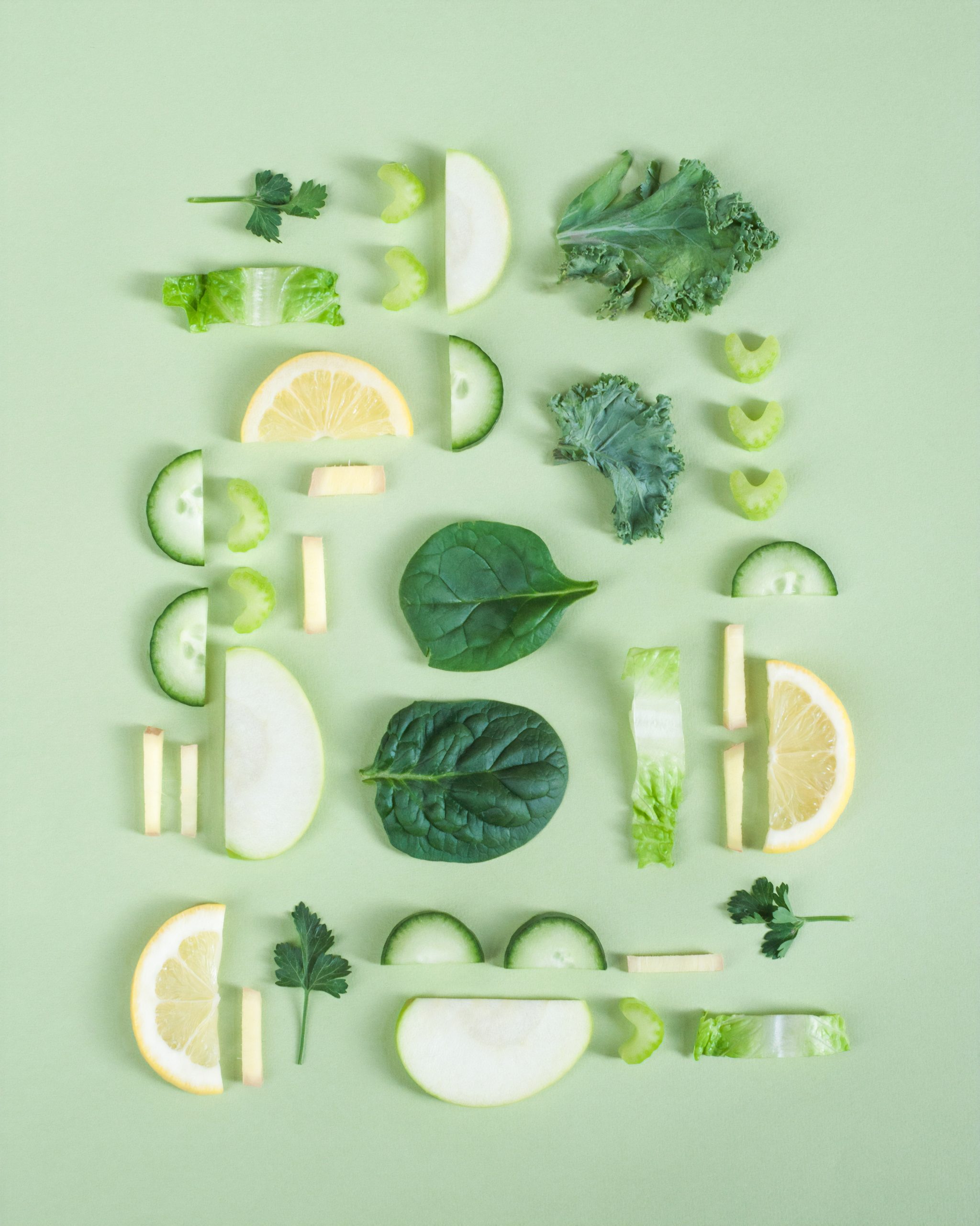 a lovely array of green and yellow fruits and vegitables on a pale green background